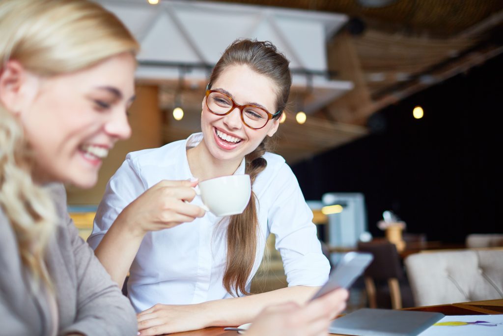 Femme souriant naturellement lors d’une conversation, posture ouverte et détendue, ambiance conviviale
